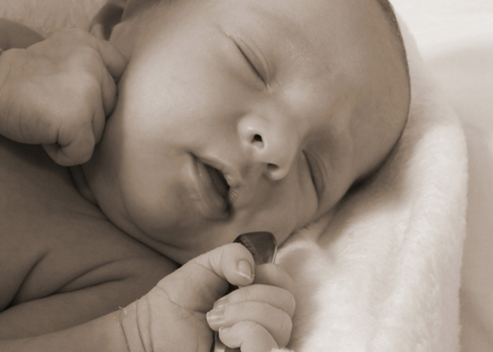 スプーンをぎゅっと握って眠っている可愛い赤ちゃん｜不妊治療HP