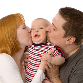 お父さんとお母さんが左右から可愛い赤ちゃんの頬にキスしているところ｜不妊治療HP
